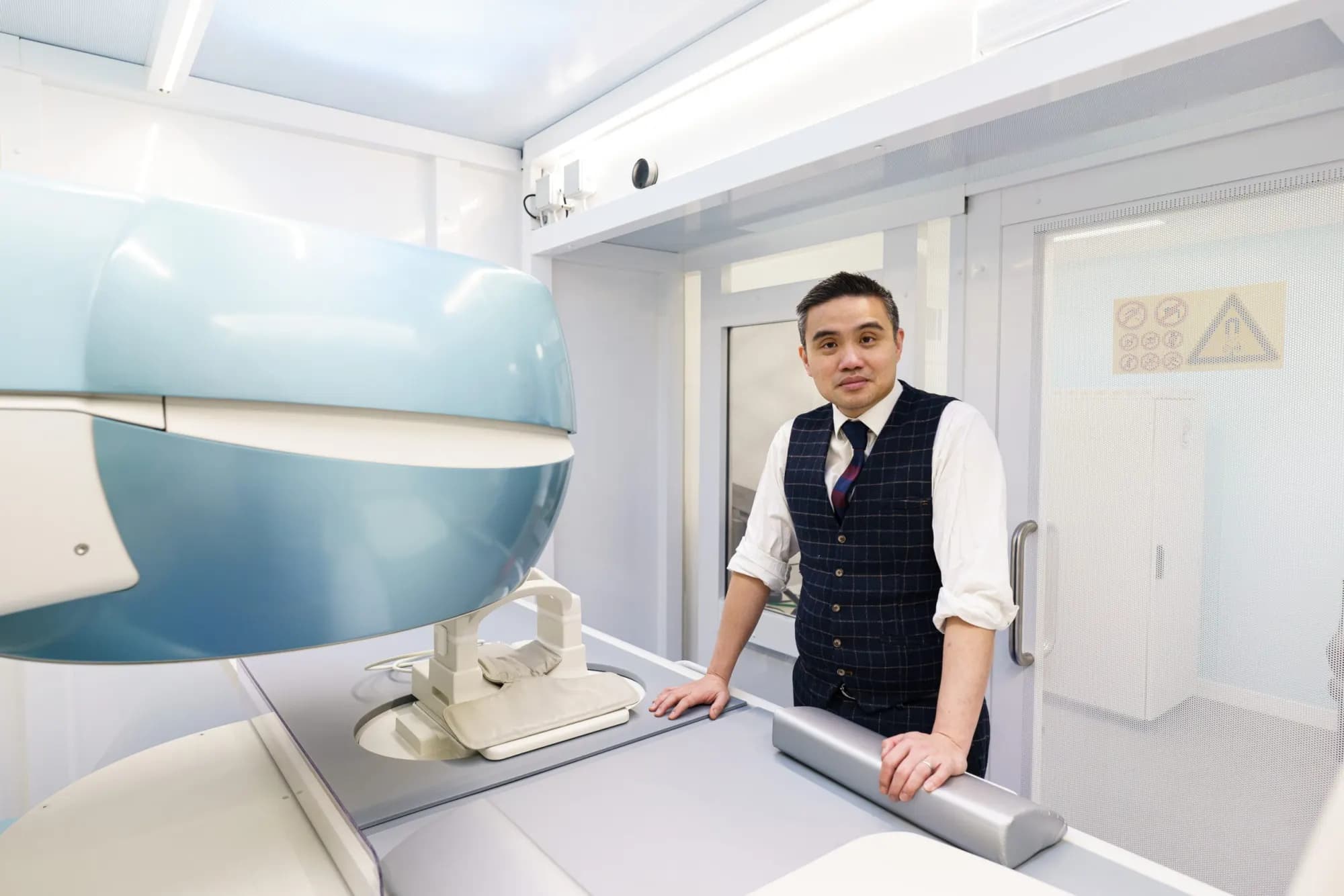 Professor Paul Lee beside the open MRI scanner at MSK House